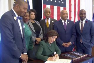 This image from video provided by the Office of The Governor shows New York Gov. Kathy Hochul signing a bill in Albany, NY, Tuesday, Dec. 19, 2023, to create a commission tasked with considering reparations to address the persistent, harmful effects of slavery in the state. She is joined by, standing from left: Dr. Yohuru Williams, Founding Director of the Racial Justice Initiative at the University of St. Thomas; Andrea Stewart-Cousins, Majority Leader of the NY State Senate; Michaelle Solages, NY State Assembly Woman; Rev. Al Sharpton; Carl Heastie, Speaker of the NY State Assembly; James Sanders, NY State Senator. (Office of the Governor via AP)