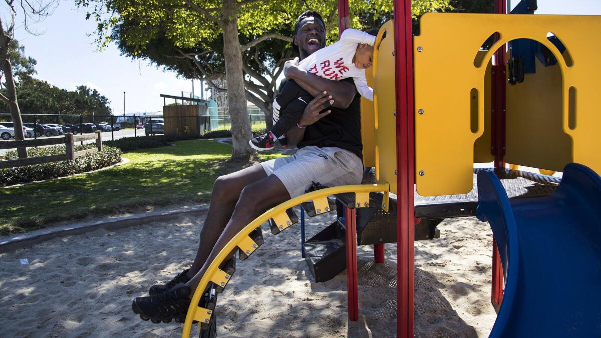 Julius Randle keeps a tight grip on 1-year-old son Kyden as they play at park near their home.