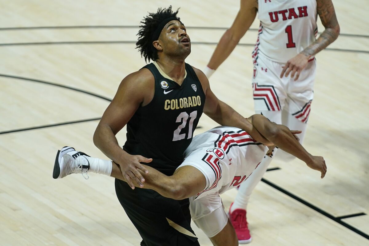 Colorado forward Evan Battey (21) battles for position under the basket with Utah guard Ian Martinez (2) in the first half during an NCAA college basketball game Monday, Jan. 11, 2021, in Salt Lake City. (AP Photo/Rick Bowmer)