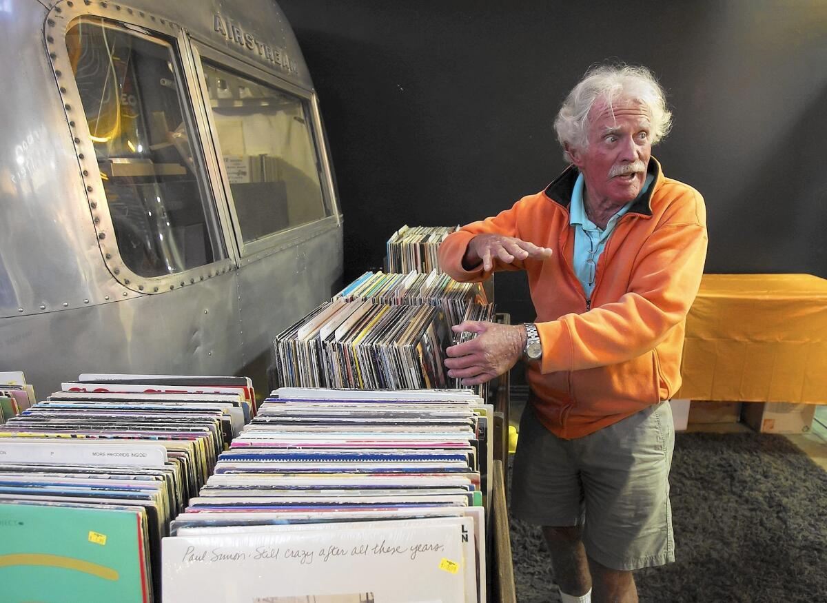 Marty Capune of Newport Beach chats about how much better the sound is on vinyl records than that on cd's as he looks through bins of new used vinyl during the Creme Tangerine record store's 5th anniversary party Friday night in Costa Mesa.