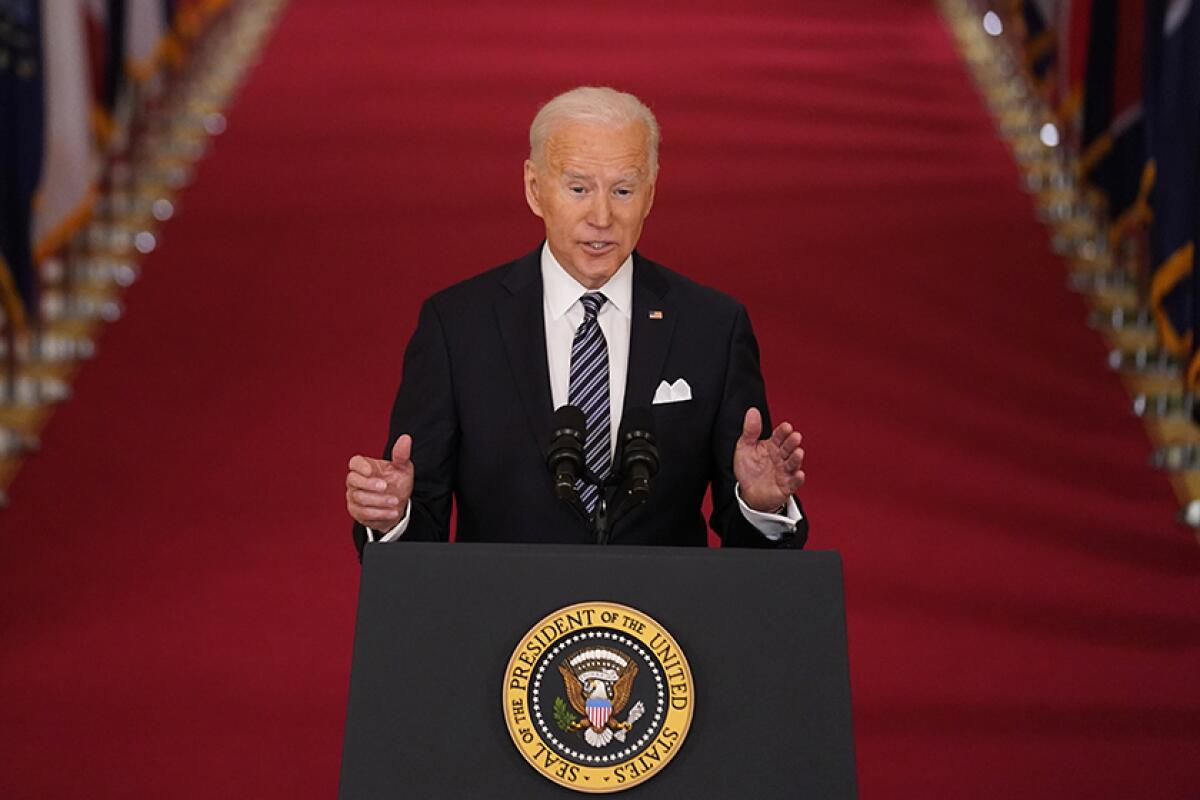 Joe Biden stands at a lectern.