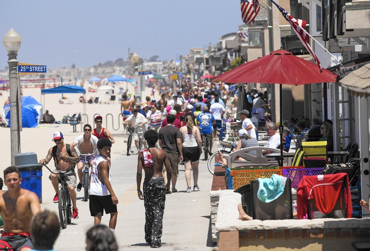 Hundreds of people crowd the Balboa Peninsula boardwalk in Newport Beach on the Fourth of July in 2014.