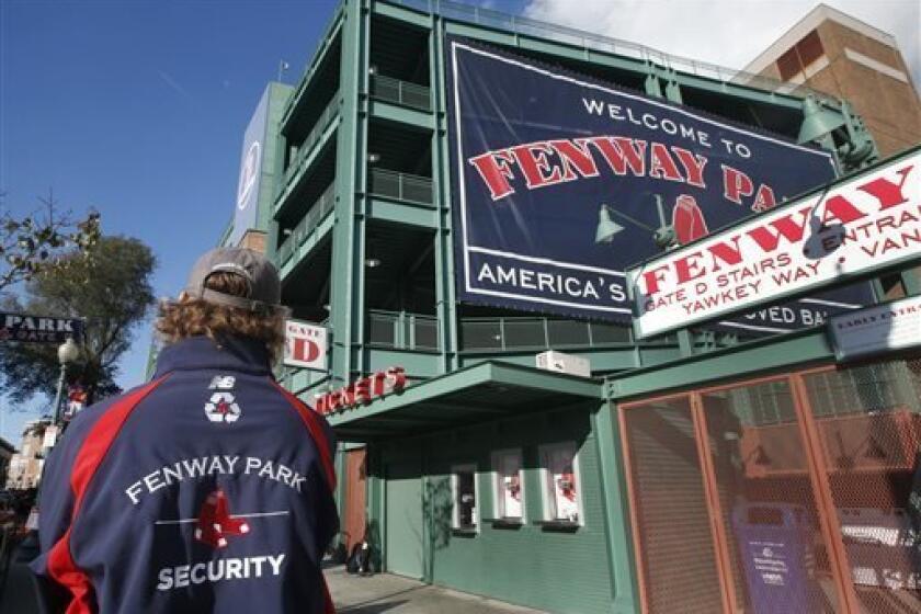 A security guard keeps an eye on things outside Gate D at Fenway Park in Boston, Tuesday, Oct. 29, 2013. If the Boston Red Sox are able to win the baseball World Series at at the stadium, police and city officials want to make sure fans celebrate responsibly. Boston holds a 3-2 lead over the St. Louis Cardinals with Game 6 and if necessary Game 7 scheduled at Fenway for Wednesday and Thursday nights. Police plan to put extra patrols on duty to guard against any unruly celebrations. (AP Photo/Eli