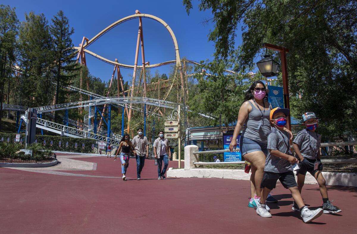 Diana Navarro and her two sons make their way inside Six Flags Magic Mountain in Valencia.