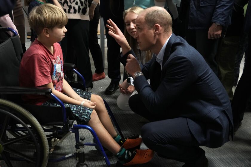 Britain's Prince William talks to a young boy as he visits an accommodation centre, for Ukrainians who fled the war, in Warsaw, Poland, Wednesday, March 22, 2023. (AP Photo/Czarek Sokolowski)