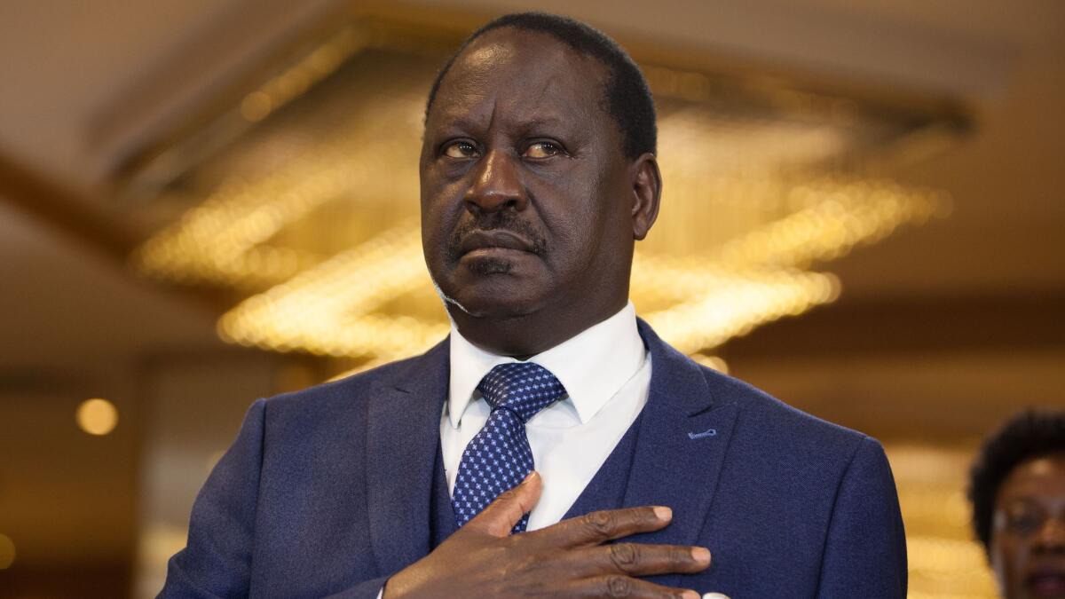 Kenyan opposition leader Raila Odinga stands for the national anthem at a news conference in Nairobi. He is expected to be sworn in as an alternative president Tuesday.