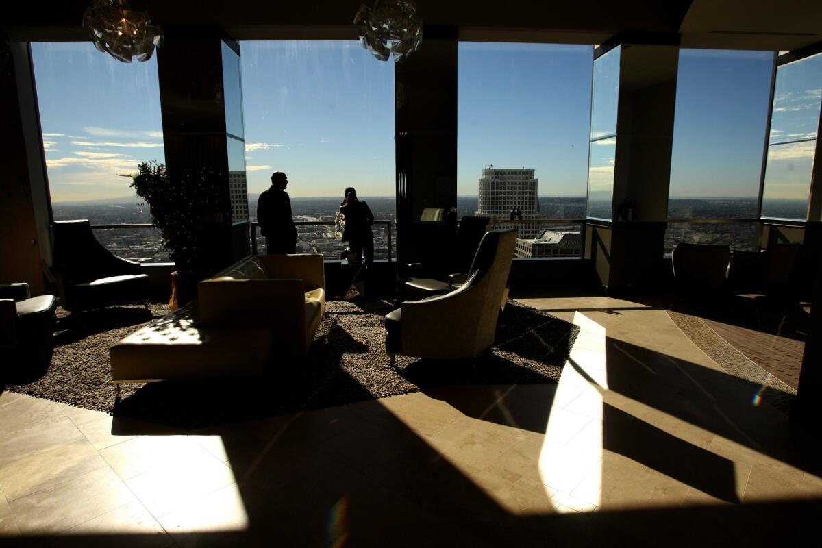 A pair of visitors take in the view overlooking downtown Los Angeles from the City Club on the 51st floor of the City National Bank Building.