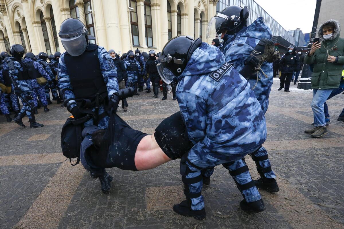 Police carry away a protester in Moscow.