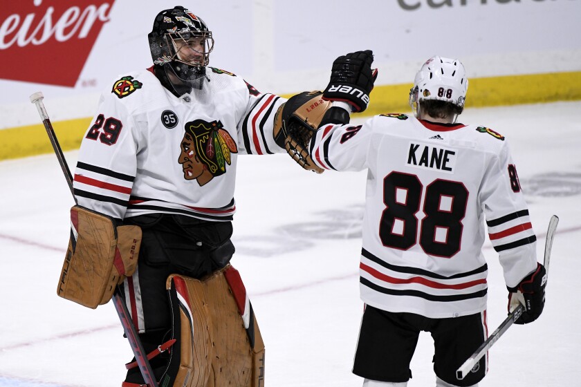 Chicago Blackhawks goaltender Marc-Andre Fleury (29) celebrates with Patrick Kane (88) after the Blackhawks scored against the Winnipeg Jets during the third period of an NHL hockey game in Winnipeg, Manitoba, Monday, Feb. 14, 2022. (Fred Greenslade/The Canadian Press via AP)