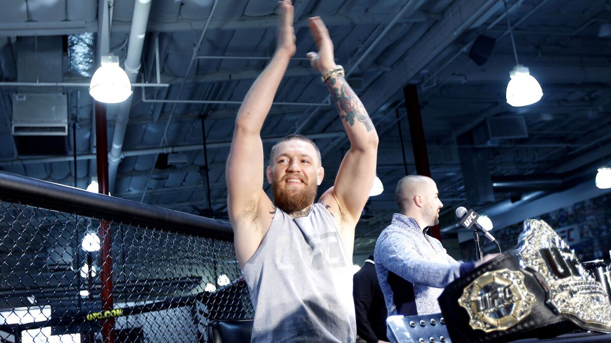 Conor McGregor acknowledges the fans with a clap of his own during a news conference in Torrance on Feb. 24.