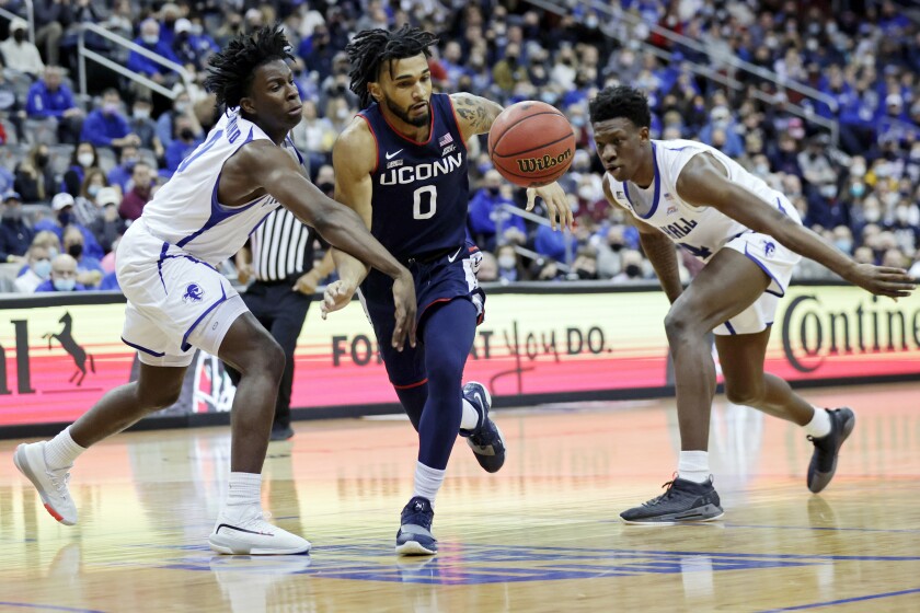 Connecticut guard Jalen Gaffney (0) has the ball knocked away by Seton Hall guard Kadary Richmond, left, during the first half of an NCAA college basketball game Saturday, Jan. 8, 2022, in Newark, N.J. (AP Photo/Adam Hunger)
