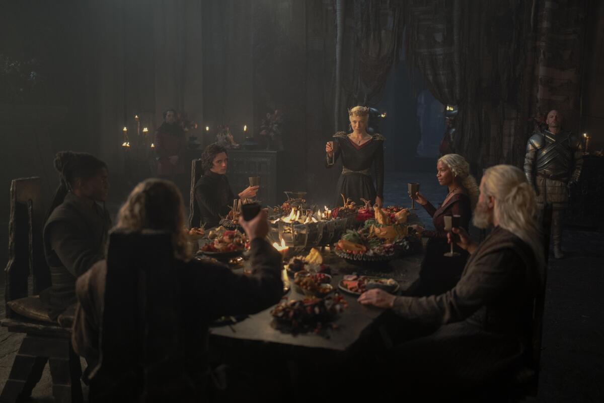 A group of men and women toasting at a feast.