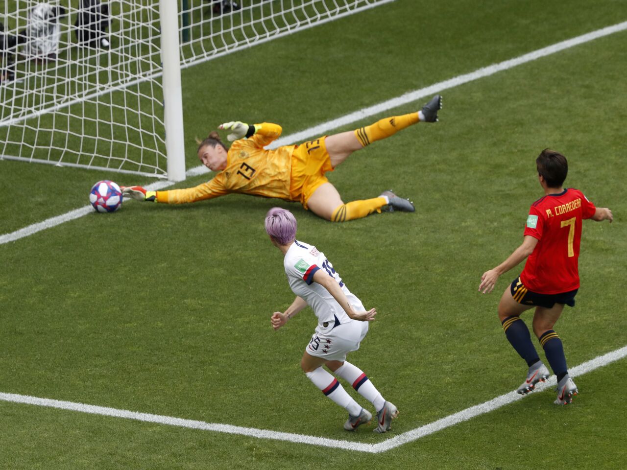 Spain goalkeeper Sandra Panos makes a save in front of Megan Rapinoe, front left, of the U.S.
