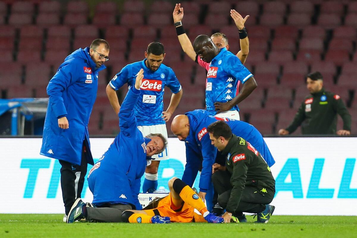 Italian referee Paolo Valeri (Rear) and staff call for medics after Napoli's Colombian goalkeeper David Ospina (Bottom) lost consciousness after sustaining a head injury during the Italian Serie A football match Napoli vs Udinese at the San Paolo stadium in Naples.