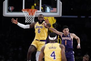 Los Angeles Lakers' LeBron James, left, reacts after missing a basket under pressure from Phoenix Suns' Devin Booker during first half of an NBA basketball game Tuesday, Dec. 21, 2021, in Los Angeles. (AP Photo/Jae C. Hong)