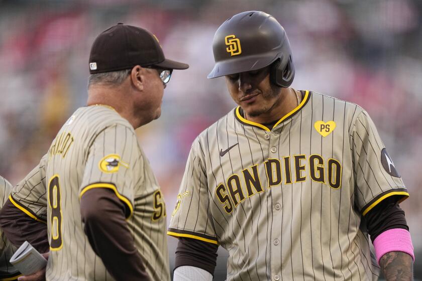 San Diego Padres' Manny Machado, right, talks with manager Mike Shildt before being taken out of the game with an injury during the fourth inning of a baseball game against the Los Angeles Angels Wednesday, June 5, 2024, in Anaheim, Calif. (AP Photo/Mark J. Terrill)