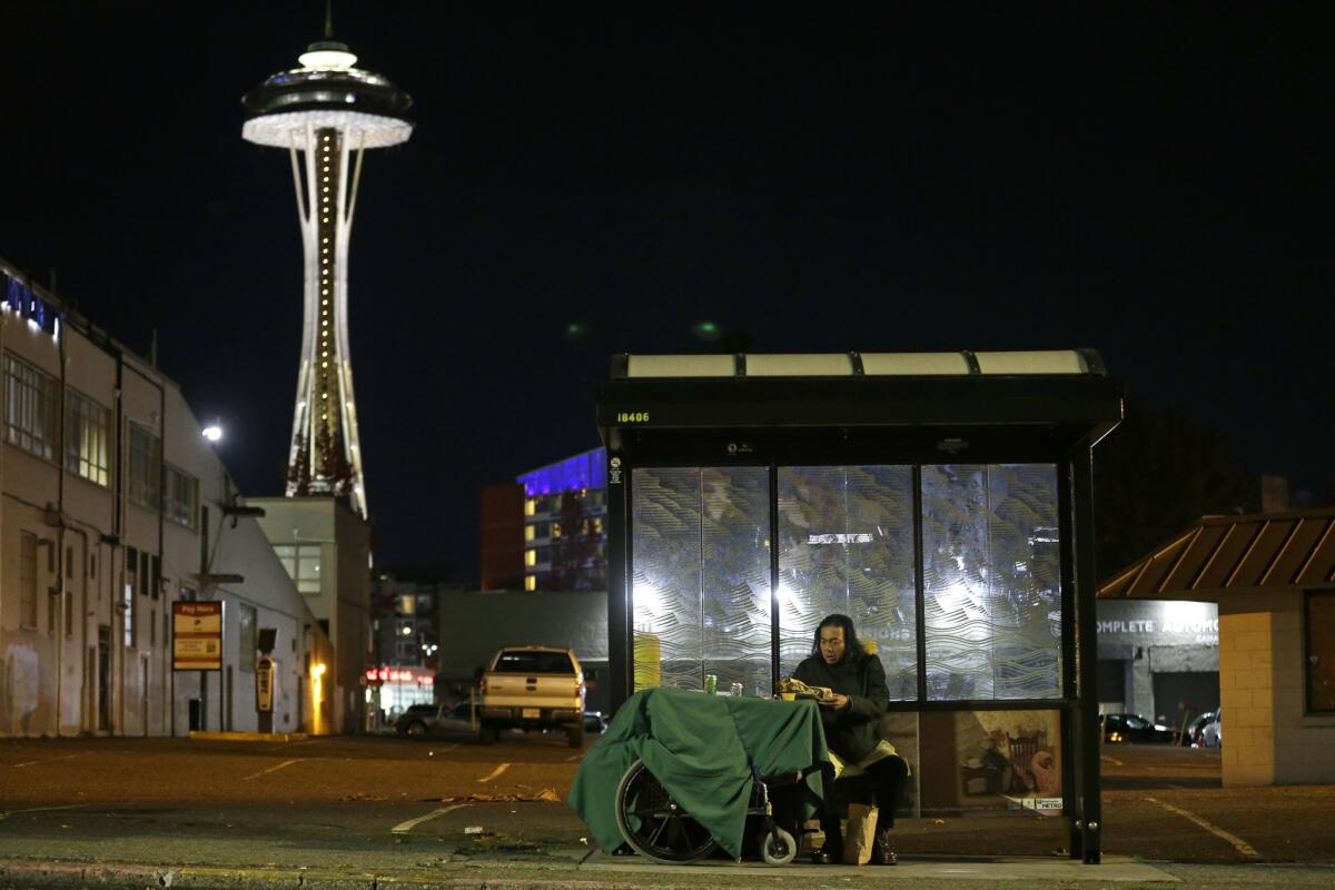 The Space Needle looms over a homeless man in Seattle. Officials estimate that 20% of the homeless population in the city live in vehicles.