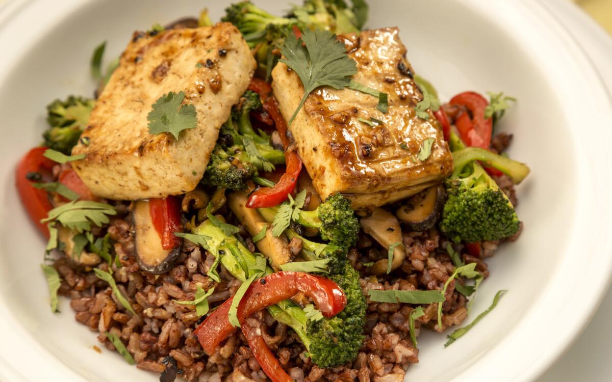 Garlic fried rice bowl with baked marinated tofu and stir-fried vegetables