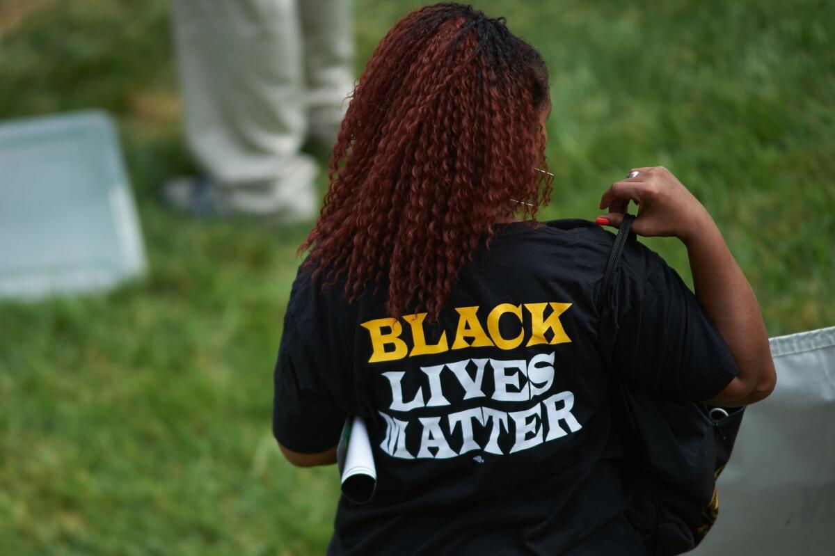 A woman wears a shirt with "Black Lives Matter" during a memorial service for slain 18 year-old Michael Brown Jr. on August 9, 2015 at the Canfield Apartments in Ferguson, Missouri.