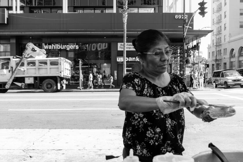 A street vendor prepares an elote