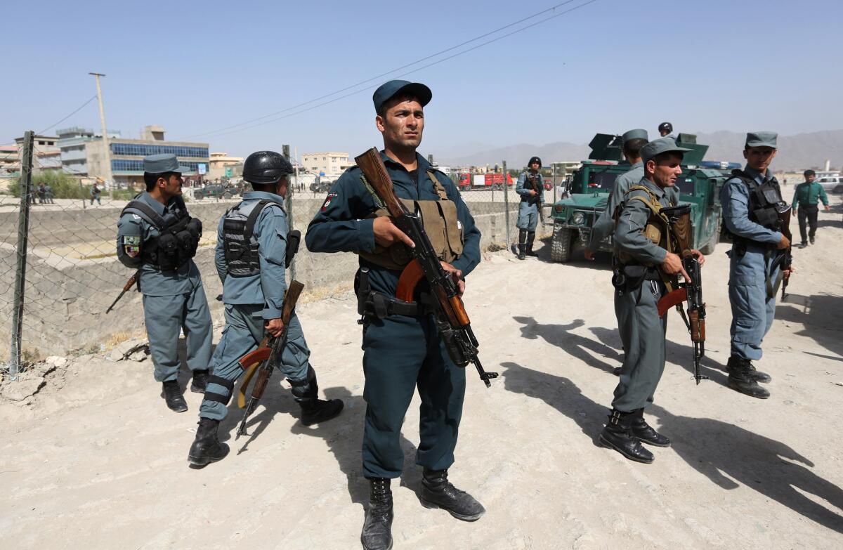 Afghan security forces inspect the site of a suicide attack that targeted a NATO convoy in Kabul on July 7, one of a series of recent attacks that came despite moves toward peace talks between the two sides.
