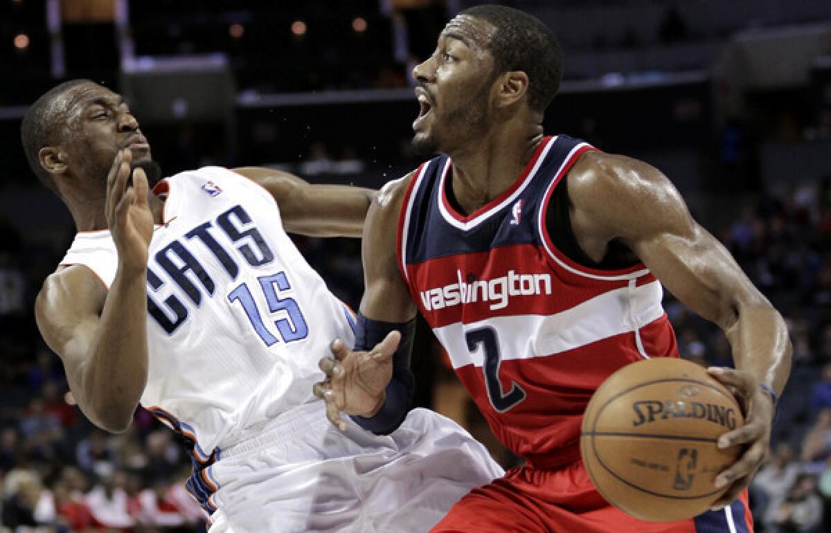 Wizards point guard John Wall collides with Bobcats point guard Kemba Walker on a drive in the second half of a game Monday.