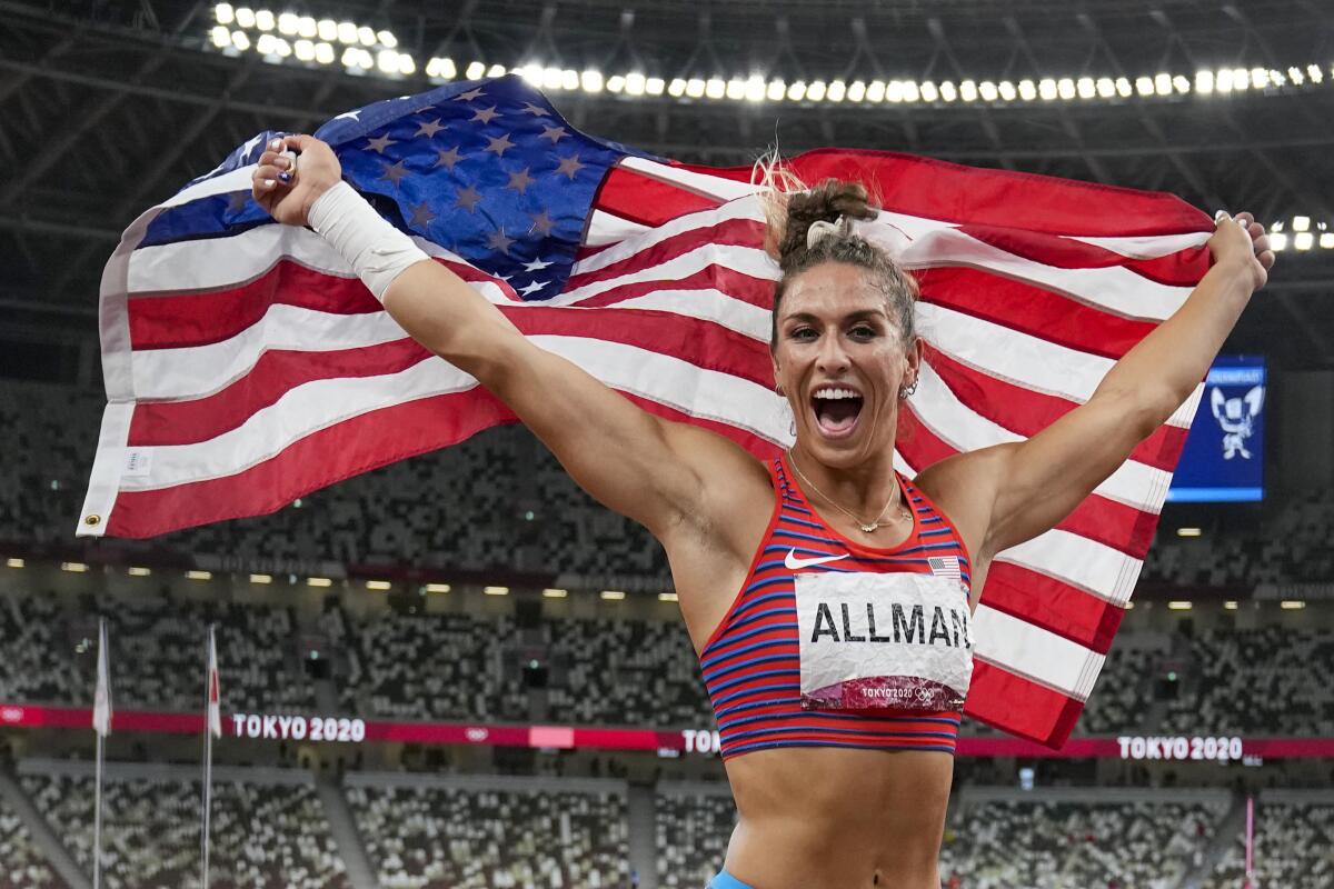 U.S. discus thrower Valarie Allman holds the U.S. flag over her head 