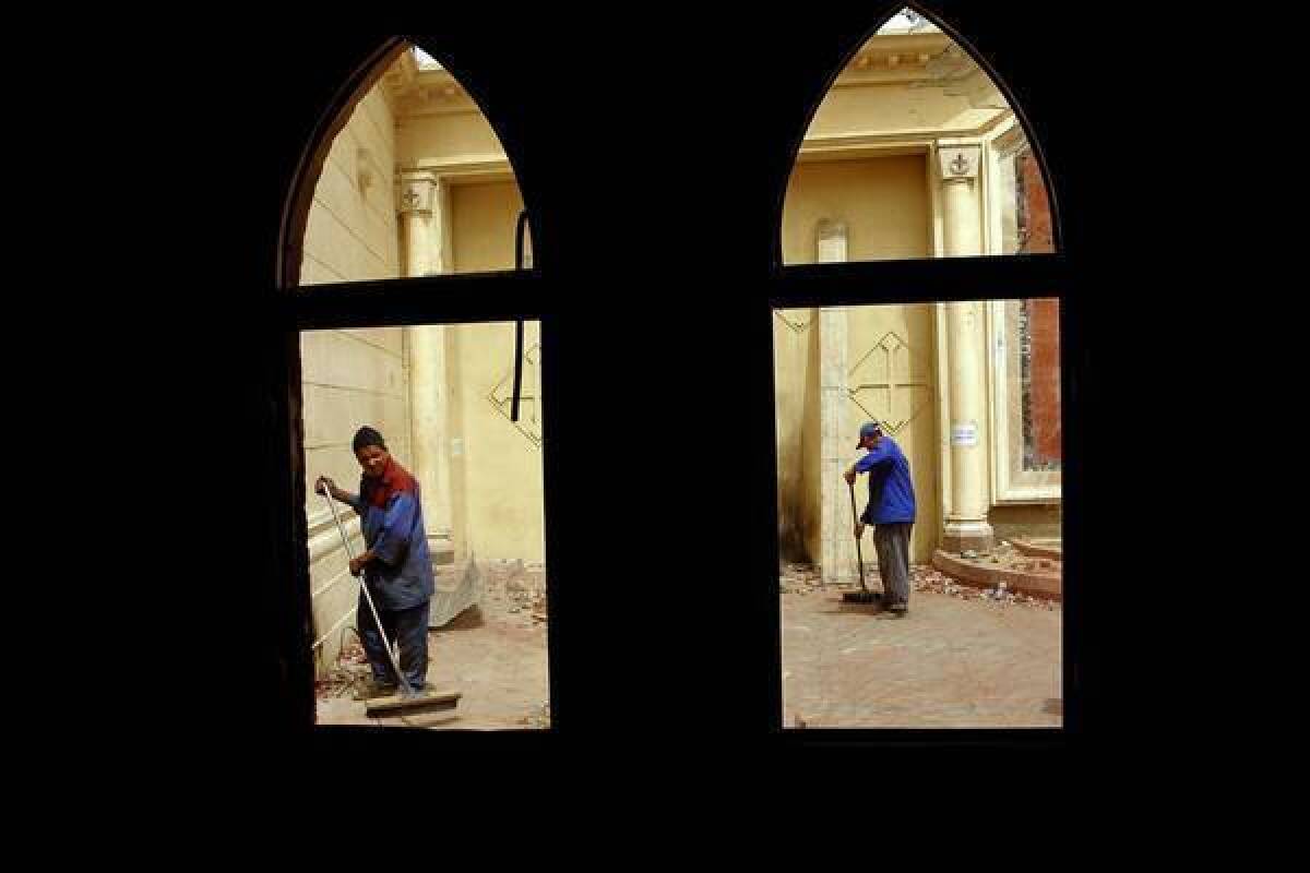 Workers clean up debris in the aftermath of sectarian violence between Muslims and Coptic Christians outside St. Mark's Cathedral in Cairo last weekend. One Copt died in bursts of tear gas, gunfire and gasoline bombs.