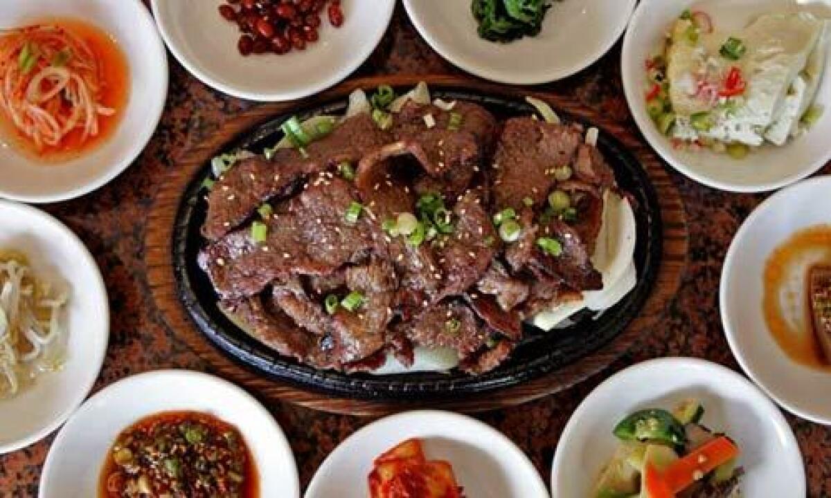 Marinated sliced beef with assorted small plates at Seongbukdong Korean restaurant.