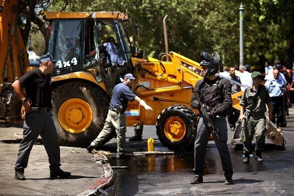 Israeli security forces secure the site of a bulldozer attack in Jerusalem's King David Street on Tuesday. The bulldozer driver was shot dead by an Israeli after he attacked two cars with the vehicle, injuring as many as seven people, police said. The incident appeared to be a copycat of one on July 2, when a Palestinian in Jerusalem killed three people and wounded 30 others when he rammed a bulldozer into a bus and cars on a busy street before being shot dead.