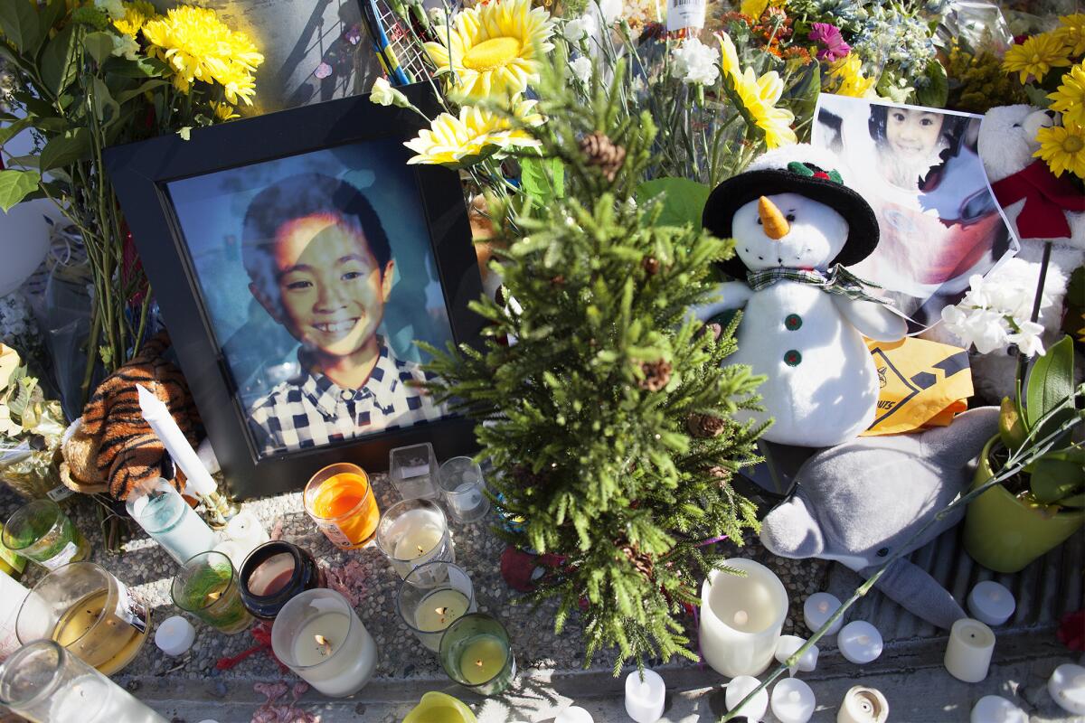 A portrait of Kevin Jiang, 9, is propped against a traffic light amid a makeshift memorial at the intersection of Roosevelt and Bay Tree in Irvine on Monday, Nov. 23. Kevin was fatally hit by a car while riding his bicycle near the intersection on Friday.