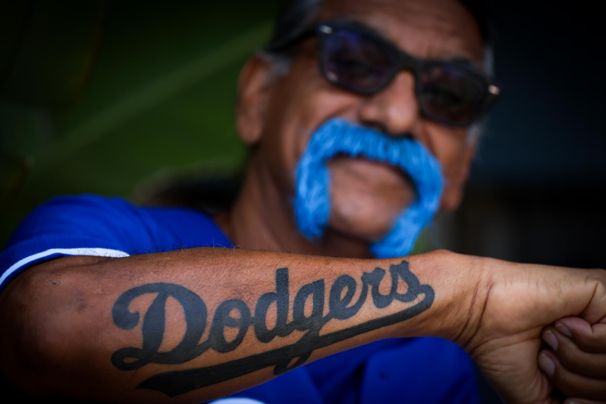 Arte Navarrete shows off his Dodgers tattoo before the game.
