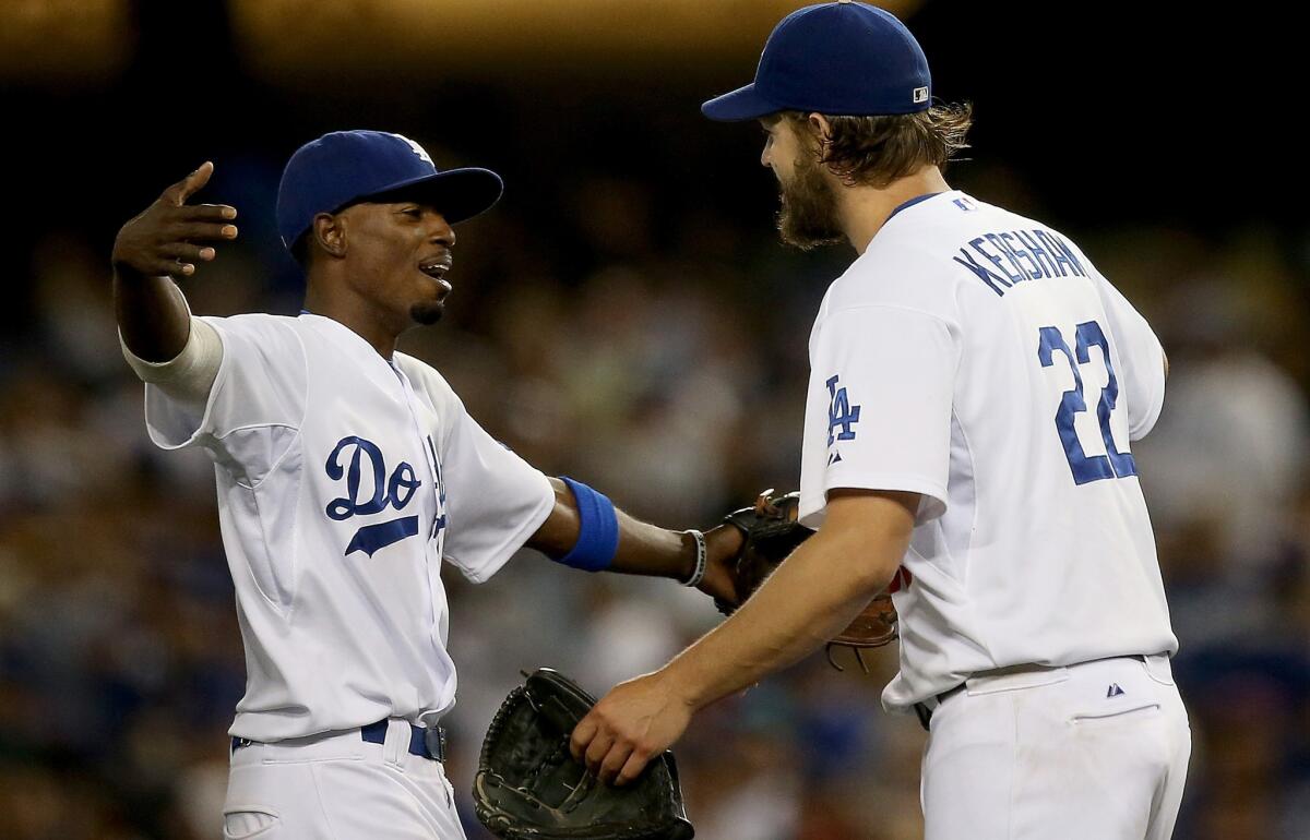 Clayton Kershaw and Dee Gordon celebrate after the Dodgers' 2-1 win Thursday over the Padres. Kershaw (11-2) gave up one run, ending his scoreless innings streak at 41, while holding San Diego to just three hits.