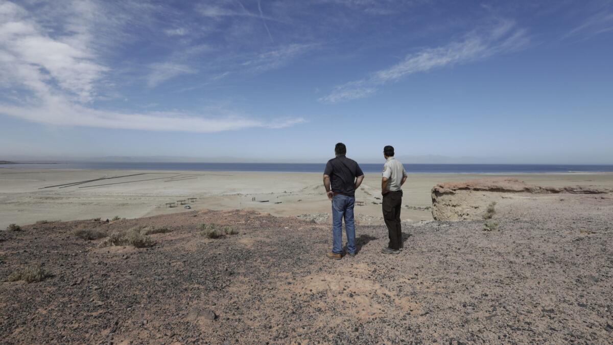 An air pollution control officer and a naturalist examine the state-funded habitat restoration and dust suppression project at Red Hill Bay overlooking the Salton Sea in Calif. on April 11, 2018.