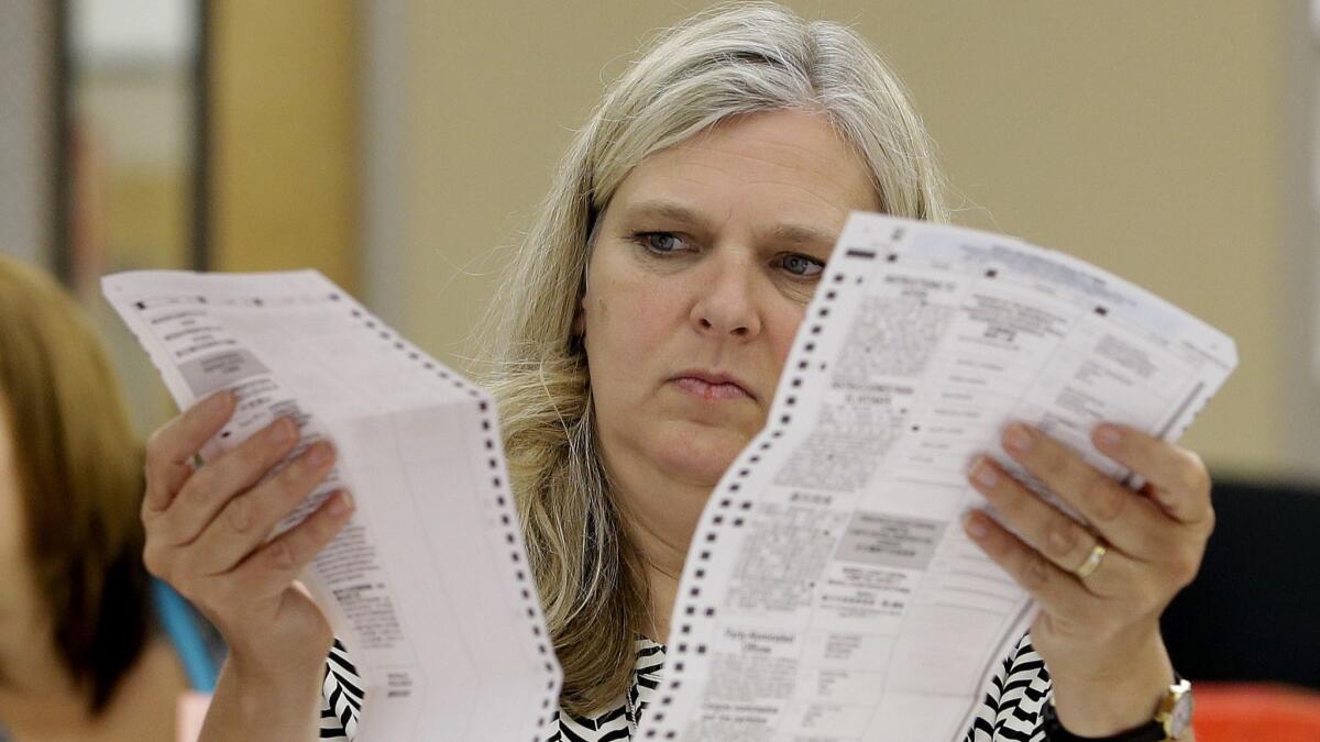 A worker at the Sacramento County Registrar of Voters office, inspects a mail-in ballot.