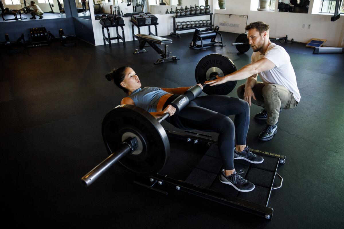 Trainers Jason Walsh and Alyssa Shoji demonstrate weighted hip thrusts. Walsh was Brie Larson's personal trainer for "Captain Marvel."
