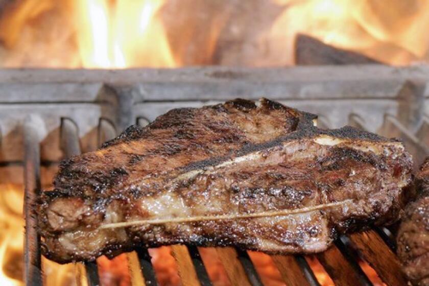 A 32-ounce Porterhouse steak is cooked over a wood fire at Cut in Beverly Hills.