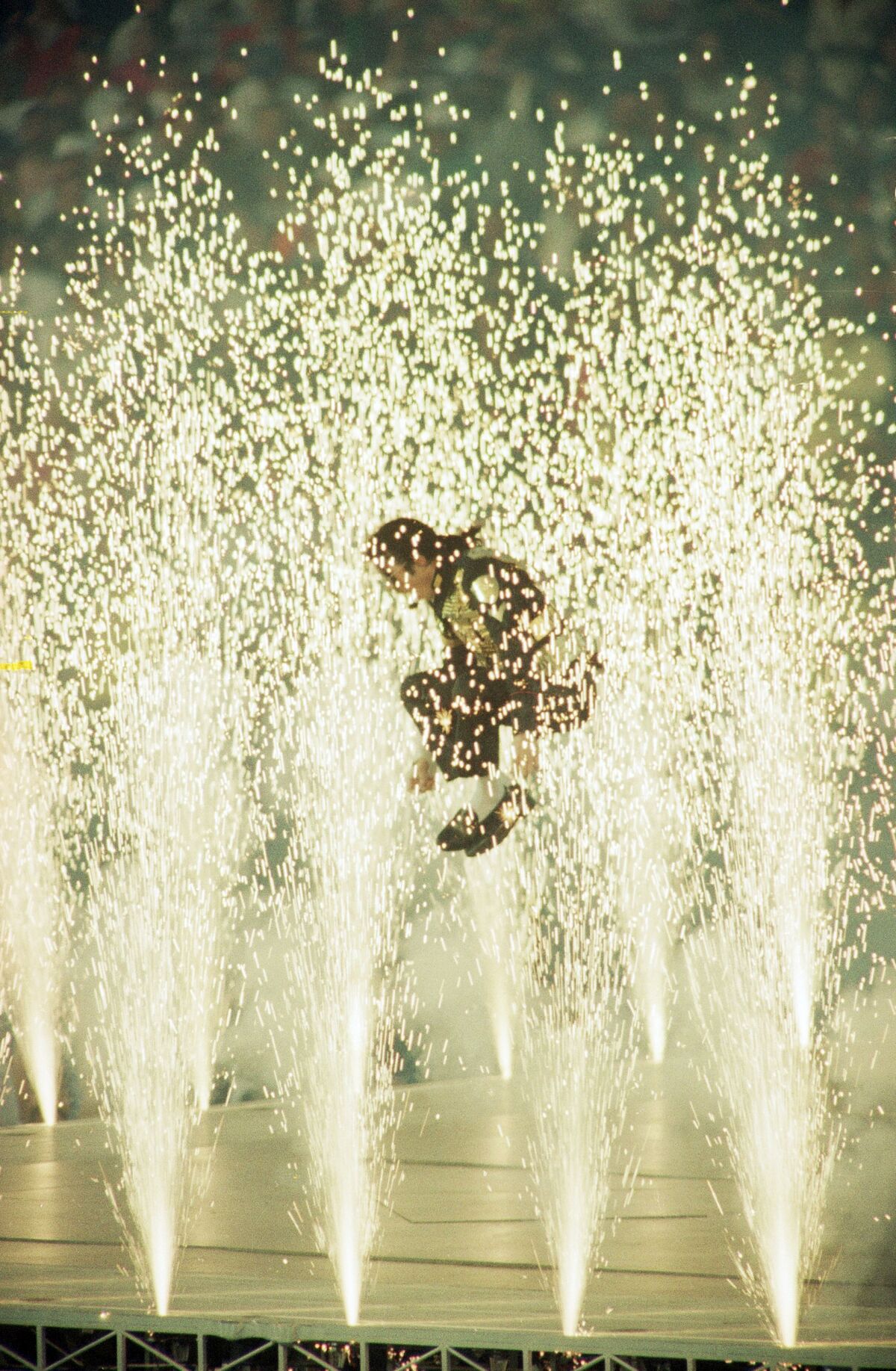 Michael Jackson leaps among the pyrotechnics during the halftime show at Super Bowl XXVII.