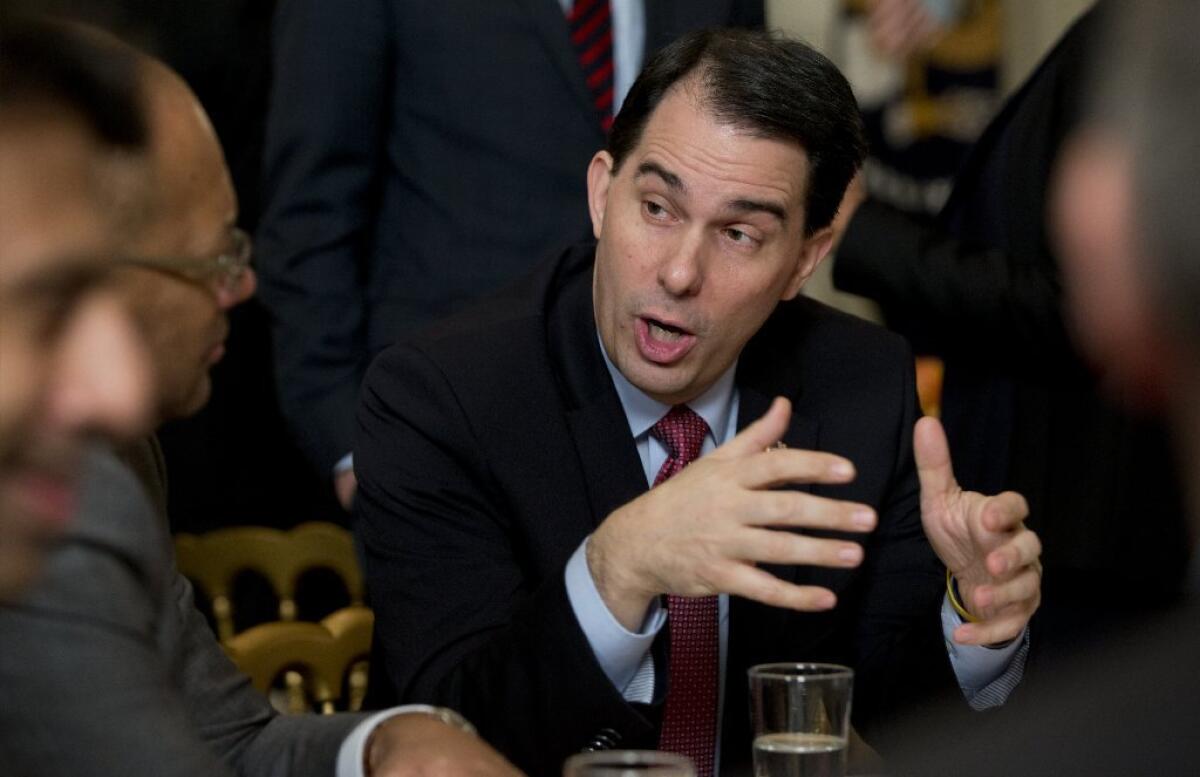 Wisconsin Gov. Scott Walker talks to other attendees before President Obama arrives to address the National Governors Assn. on Monday at the White House