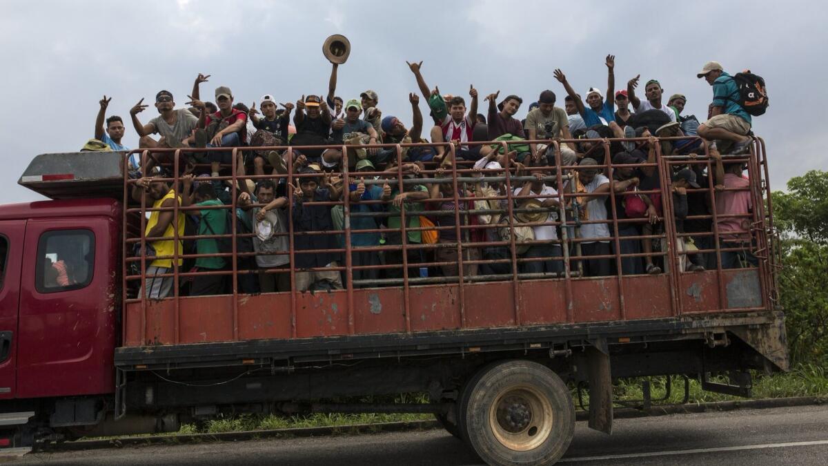 Central American migrants, part of the caravan hoping to reach the U.S. border, get a ride Nov. 2 on a truck in Donaji, Oaxaca state, Mexico.
