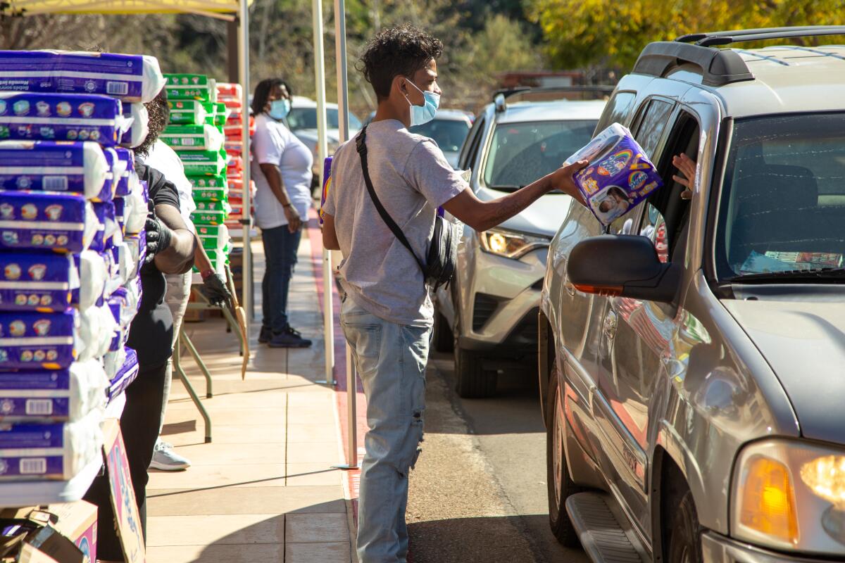 Imran Hasan distributes diapers to families during a food distribution event on Tuesday, March 2, 2021 in San Diego, CA.