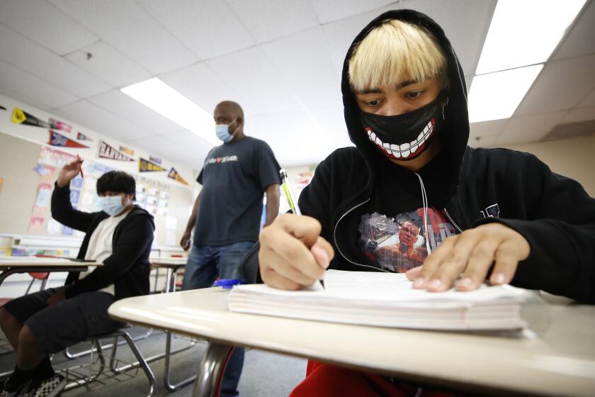 HAWTHORNE, CA - JULY 26: Junior student Robert Menjivar, right, is masked in the Math 2 class of teacher Cordell Haynes, as students attend the last two day's of summer school at Hawthorne High School in the South Bays Centinela Valley Union High School District which didn't reopen in the spring, and instead reopened for in-person summer instruction. The students are finishing 5 weeks of the summer school session. Various summer schools are in session, and some districts see them as a trial run for the fall when it comes to protocols like distancing and masking mandates. Hawthorne High School on Monday, July 26, 2021 in Hawthorne, CA. (Al Seib / Los Angeles Times).