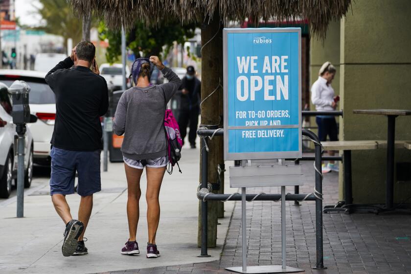 In this May 12, 2020 photo, customers walk past an open sign at Rubio's Coastal Grill on Tuesday, May 12, 2020, in Long Beach, Calif. (AP Photo/Ashley Landis)