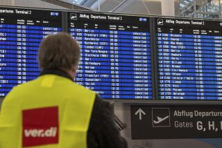 Un empleado aeroportuario, con un chaleco del sindicato ver.di, delante de una pantalla con información de vuelos en el aeropuerto de Fráncfort, Alemania, el 17 de febrero de 2023. (Arne Dedert/dpa via AP)