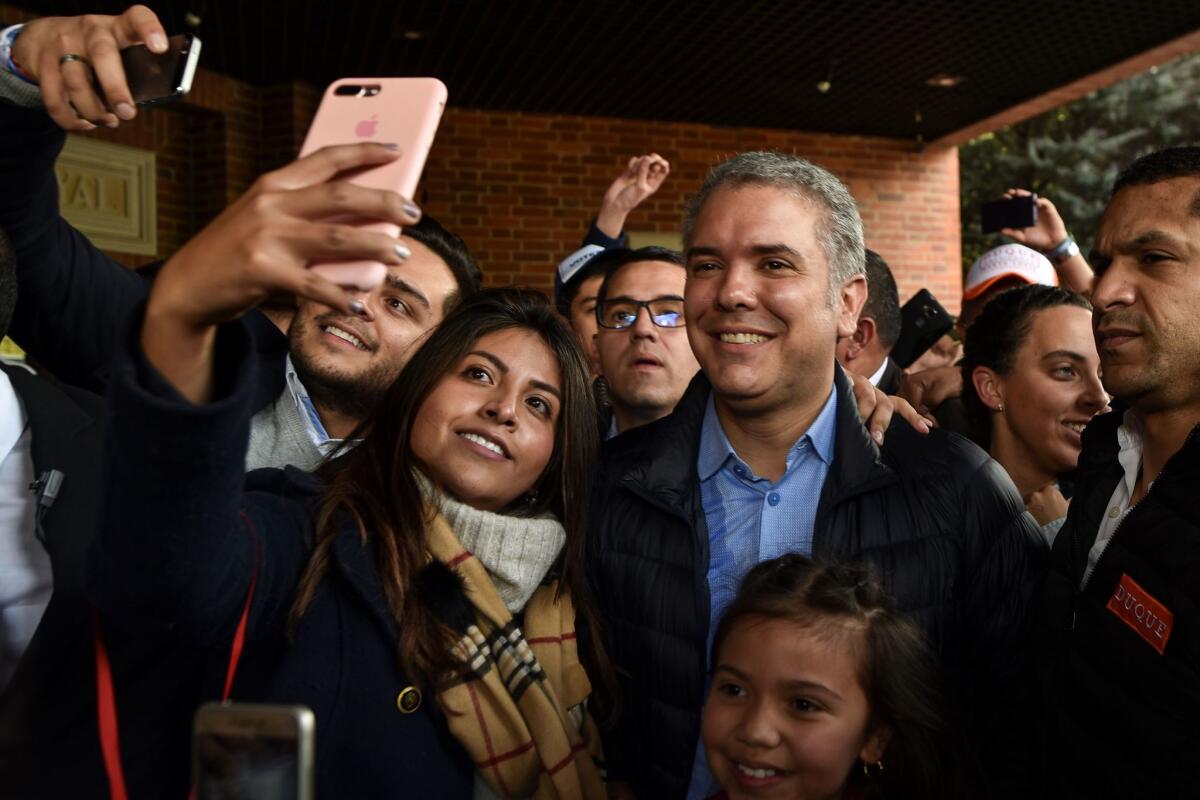 Hard-line Colombian presidential candidate Ivan Duque, shown Friday with supporters in Bogota, is a harsh critic of a peace deal with former rebels and is favored by a powerful former president.