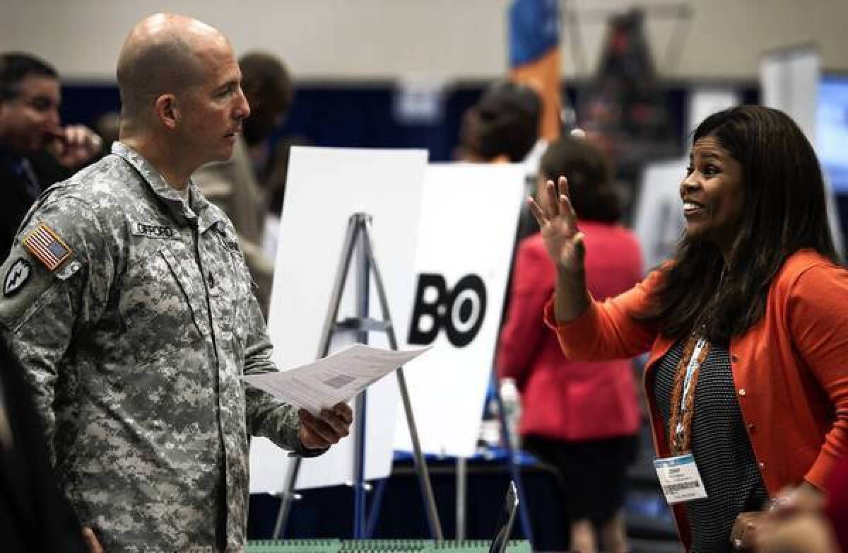 A soldier speaks with a job recruiter during the Hiring Our Heroes job fair in Washington, D.C. The job fair was held in conjunction with the annual convention of the National Cable and Telecommunications Assn., with dozens of telecommunications firms represented.