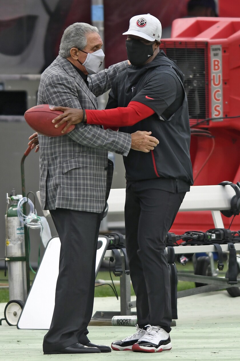 Atlanta Falcons owner Arthur Blank, left, hugs head coach Raheem Morris before an NFL football game against the Tampa Bay Buccaneers Sunday, Jan. 3, 2021, in Tampa, Fla. (AP Photo/Jason Behnken)