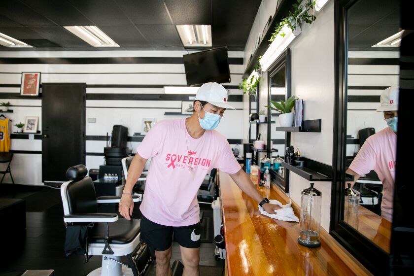 Rennan Pizarro, owner of Sovereign Barbershop on 30th Street in North Park, makes preparations to open his store as early as next week after the county gave the go-ahead for stores like his to begin reopening on May 26, 2020 in San Diego, California.
