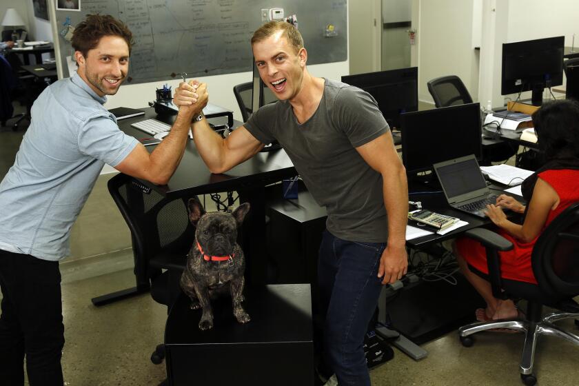 SANTA MONICA, CA-AUGUST 5, 2015: Jaspar Weir, 29, left, and Bryce Maddock, 29, co-founders of TaskUs, which provides outsourced call center/customer service operations for Uber, Groupon, Tinder, and other big Internet companies, are photographed at their U.S. Headquarters in Santa Monica on August 5, 2015. Below them is Maddock's dog, Mr. Carter, a 2 and 1/2 year old French Bulldog. (Mel Melcon/Los Angeles Times)