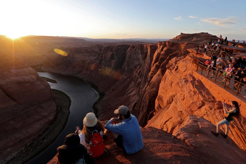 PAGE, ARIZONA - MAY 16, 2022. Scores of visitors get a view and pictures of the sun setting on Horseshoe Bend on the Colorado River near Page, the gateway to the Glen Canyon Dam Recreation Area. Once a little-known landmark, the popularity of Horseshoe Bend has exploded with social media and now attracts more than 2 millions visitors each year. (Luis Sinco / Los Angeles Times)